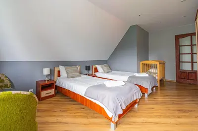 a bedroom with two beds and a chair at U Kowola - Gospodarstwo Agroturystyczne in Węglówka