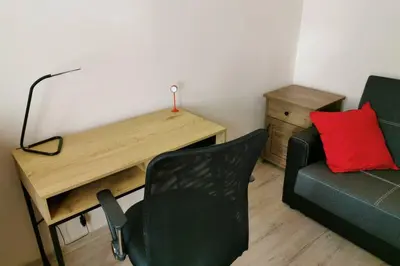 a room with a desk and a couch and a chair at Little Big Red - Central Modern Studio in Kraków