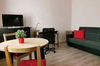 a living room with a couch and a table at Little Big Red - Central Modern Studio in Kraków