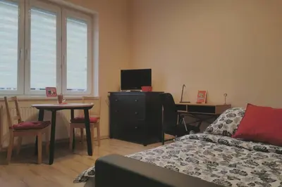 a living room with a couch and a table with a tv at Little Big Red - Central Modern Studio in Kraków