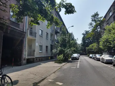 an empty street with cars parked on the side of a building at Little Big Red - Central Modern Studio in Kraków