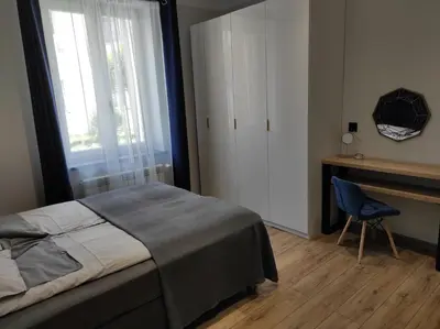 a bedroom with a bed and a desk and a chair at Mirror Apartments in Oświęcim