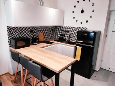 a kitchen with a wooden table and a black refrigerator at Mirror Apartments in Oświęcim