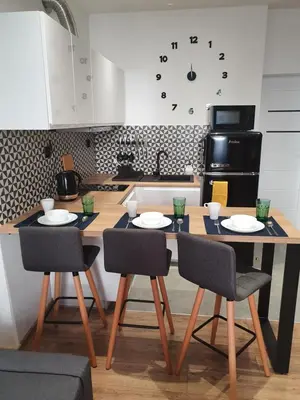 a kitchen with a wooden table with chairs and a tableasteryasteryasteryasteryastery at Mirror Apartments in Oświęcim