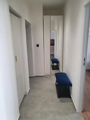 an empty hallway with a blue bench and a door at Mirror Apartments in Oświęcim