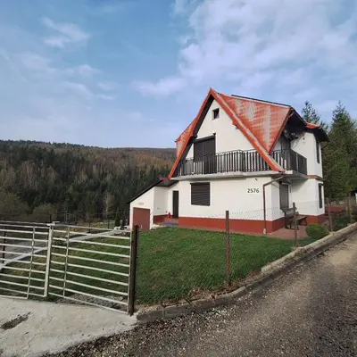 a small bedroom with a bed and a chair at Domek Zawoja in Zawoja