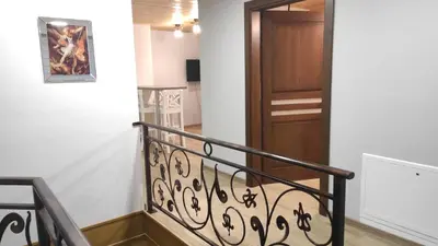a staircase with a wrought iron railing and a wooden door at Gospodarstwo agroturystyczne U Kierpców. in Podwilk