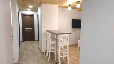 a kitchen with a table and stools in a room at Gospodarstwo agroturystyczne U Kierpców. in Podwilk