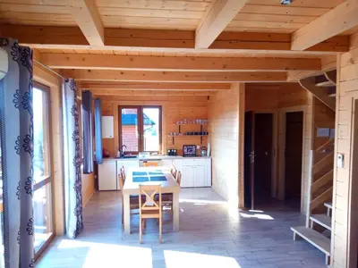 a kitchen with a table and chairs in a house at Słoneczne Chaty Kasina Wielka in Kasina Wielka