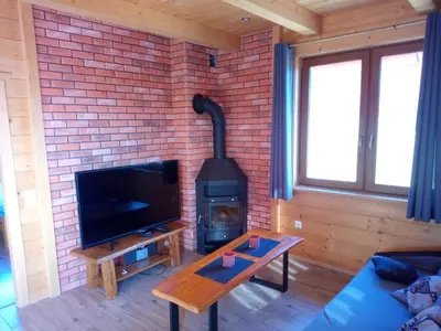 a living room with a brick wall and a stove at Słoneczne Chaty Kasina Wielka in Kasina Wielka