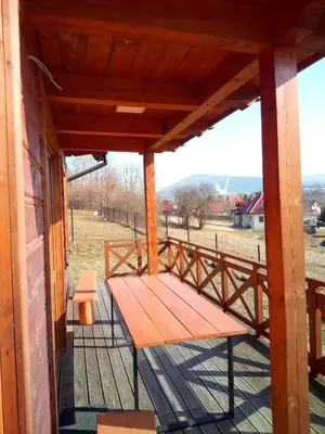 a wooden bench on the porch of a house at Słoneczne Chaty Kasina Wielka in Kasina Wielka