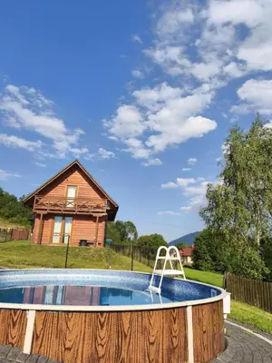 a swimming pool in front of a house at Słoneczne Chaty Kasina Wielka in Kasina Wielka