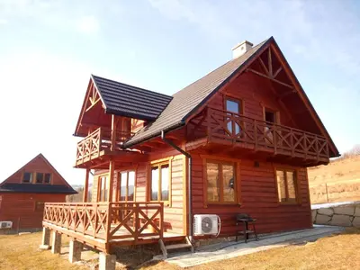 a log cabin with a gambrel roof at Słoneczne Chaty Kasina Wielka in Kasina Wielka
