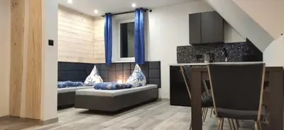 a living room with two beds and a kitchen at Pokoje Gościnne Tyrol in Zawoja