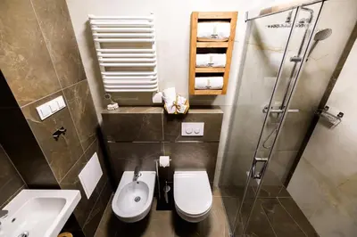 a bathroom with a toilet and a sink and a shower at Apart Residence Ariańska 16 by NEARTO PL in Kraków