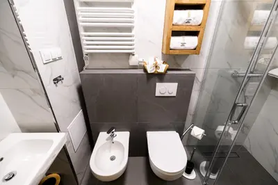 a bathroom with a white toilet and a sink at Apart Residence Ariańska 16 by NEARTO PL in Kraków