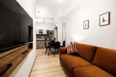 a living room with a couch and a television at Apart Residence Ariańska 16 by NEARTO PL in Kraków