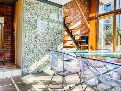 a glass table and two chairs in front of a wall at Zwierzyniecka Lofts with Patio and Air Conditioning, Cracow city heart Old Town in Kraków