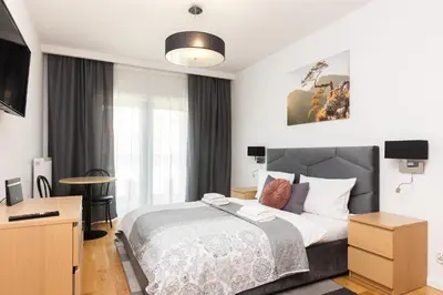 a bedroom with a large bed and a desk at Old Town Rajska street in Kraków