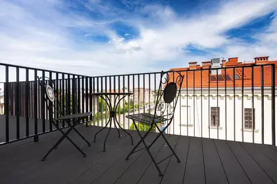 two chairs and a table on a balcony with a building at Old Town Rajska street in Kraków