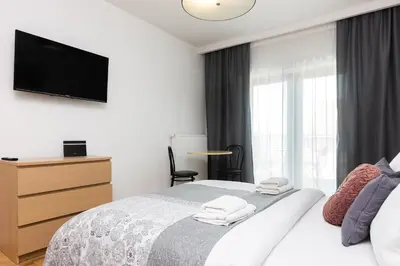 a bedroom with a bed with a television on the wall at Old Town Rajska street in Kraków