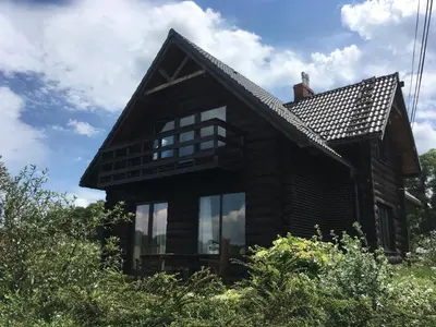 a house with glass windows on the side of it at Chata na Łąkach in Jerzmanowice