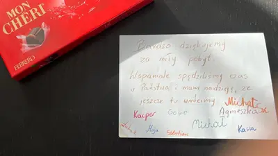 a handwritten note sitting on a table next to a book at Chata na Łąkach in Jerzmanowice
