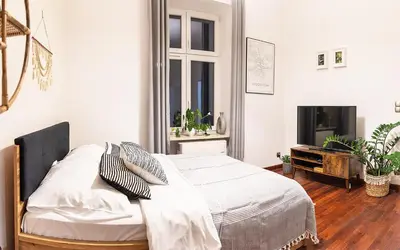 a bedroom with a bed and a tv in it at Mateyko Boho in Kraków