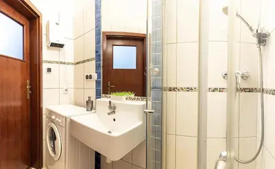 a bathroom with a sink and a shower at Mateyko Boho in Kraków