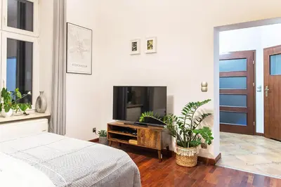 a bedroom with a flat screen tv and a bed at Mateyko Boho in Kraków