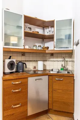 a kitchen with wooden cabinets and stainless steel appliances at Mateyko Boho in Kraków