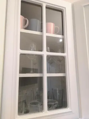 a white cabinet with cups and dishes in it at ZamStudio Kraków Zamenhofa 4 in Kraków