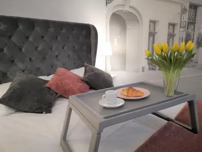 a coffee table with a vase of yellow tulips and a table with at ZamStudio Kraków Zamenhofa 4 in Kraków