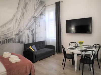 a living room with a couch and a table at ZamStudio Kraków Zamenhofa 4 in Kraków