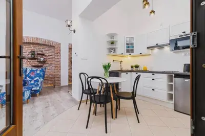 a kitchen with a table and chairs in a room at ZamStudio Kraków Zamenhofa 4 in Kraków