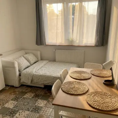 a small room with a bed and a table with chairs at Beautiful apartment with balcony in Kraków