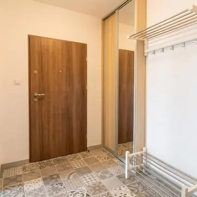 a room with a wooden door and a tiled floor at Beautiful apartment with balcony in Kraków