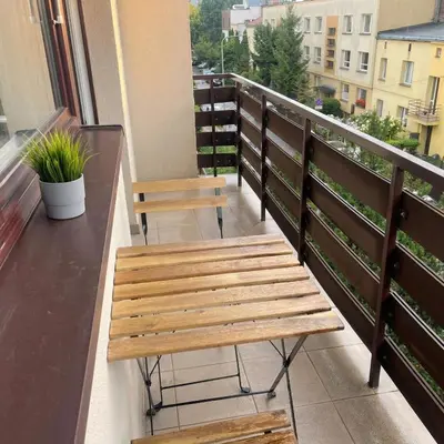 a wooden bench sitting on a balcony with a view at Beautiful apartment with balcony in Kraków