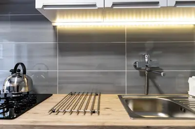 a kitchen counter with a sink and a stove at Cracow nest - 2 separate rooms, heart of Kazimierz in Kraków