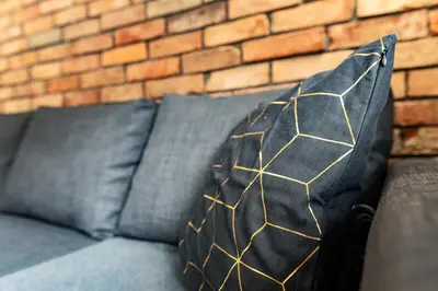 a black and gold pillow sitting on a couch at Cracow nest - 2 separate rooms, heart of Kazimierz in Kraków