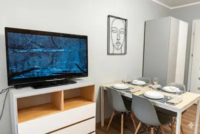 a dining room with a table with a television on it at Cracow nest - 2 separate rooms, heart of Kazimierz in Kraków