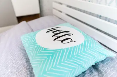 a pillow with the word new on it sitting on a bed at Cracow nest - 2 separate rooms, heart of Kazimierz in Kraków