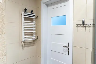 a bathroom with a shower door and white towels at Cracow nest - 2 separate rooms, heart of Kazimierz in Kraków