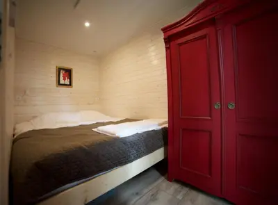 a bedroom with a bed with a red cabinet at JURA GLAMP luksusowe całoroczne domki na wyłączność KOPUŁY IGLOO taras ogród in Wola Kalinowska