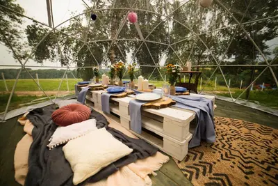 a tent with a table and chairs in it at JURA GLAMP luksusowe całoroczne domki na wyłączność KOPUŁY IGLOO taras ogród in Wola Kalinowska