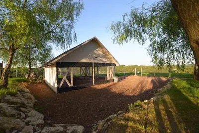 a small white building sitting on the side of a dirt road at JURA GLAMP luksusowe całoroczne domki na wyłączność KOPUŁY IGLOO taras ogród in Wola Kalinowska