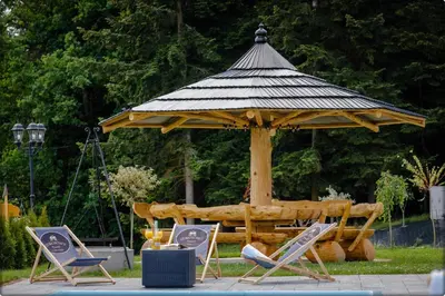 a patio with two chairs and a swimming pool at Zdrojowy Gościniec - domki Rabka-Zdrój in Rabka