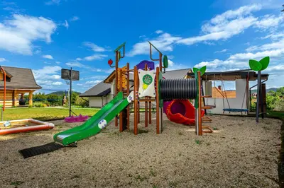 a room with a play house and a tree mural at Zdrojowy Gościniec - domki Rabka-Zdrój in Rabka