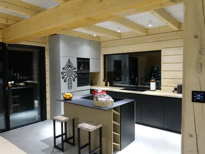a kitchen with a counter with stools in it at Domki PRemium in Zawoja