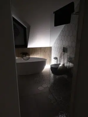 a bathroom with a tub and a toilet and a sink at Domki PRemium in Zawoja